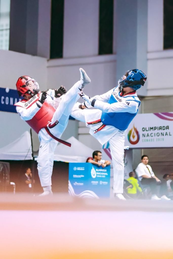 Two athletes in intense Taekwondo match at Olimpiada Nacional, Tlaxcala, Mexico.